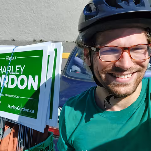 Nick in bike helmet with Harley Gordon Green Party election signs strapped behind him to bike.