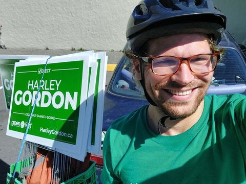 Nick in bike helmet with Harley Gordon Green Party election signs strapped behind him to bike.